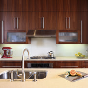 View of a kitchen which features limestone countertops, cabinetry, countertop, cuisine classique, interior design, kitchen, under cabinet lighting, red