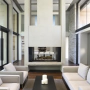 View of living area featuring double story fireplace, architecture, ceiling, floor, furniture, house, interior design, living room, table, white, gray