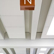 Rocket Signs developed and installed signage in the ceiling, daylighting, line, product design, white, gray