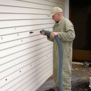Qmulus BIB dry-fibre insulation being installed by an floor, outdoor structure, roof, siding, standing, window, wood, white