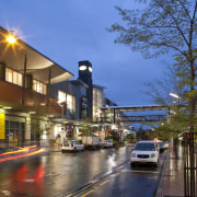 Westfield Riccarton has undergone an extension adding a car, city, downtown, evening, house, lane, metropolitan area, mixed use, neighbourhood, plant, real estate, reflection, residential area, road, sky, street, town, tree, urban area, brown, blue