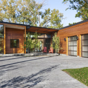 View of the exterior of the home featuring architecture, backyard, cottage, estate, facade, farmhouse, home, house, property, real estate, shed, yard, brown, gray