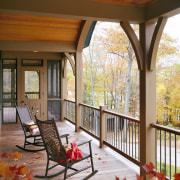 View of the holiday homes exterior featuring white deck, estate, home, house, interior design, living room, outdoor structure, patio, porch, real estate, window, brown