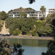 View of a large apartment development in Auckland city, estate, garden, house, lake, leaf, nature, plant, reflection, sky, tourist attraction, tree, water, brown