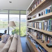 View of kitchen and living area featuring light interior design, living room, shelving, gray