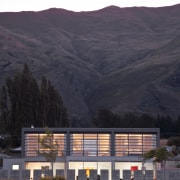 View of the homes exterior featuring plaster and architecture, dawn, evening, home, house, landscape, morning, mountain, mountain range, real estate, residential area, roof, sky, suburb, black