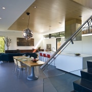 View of kitchen designed by Tim Rempel of apartment, architecture, ceiling, daylighting, floor, flooring, glass, handrail, home, house, interior design, lobby, loft, real estate, stairs, table
