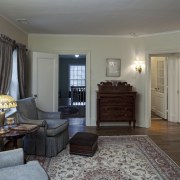 View of the sitting room featuring traditional-styled seating, bedroom, ceiling, estate, floor, flooring, hardwood, home, interior design, living room, property, real estate, room, wall, window, wood, gray, black