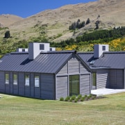 Exterior view of a country home which features cottage, elevation, farmhouse, home, house, landscape, property, real estate, roof, rural area, shed, siding, gray