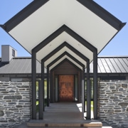 Exterior view of entrance way which features gabled architecture, building, facade, home, house, real estate, residential area, roof, structure, window, gray, black