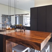 View of a contemporary kitchen which features island, countertop, furniture, interior design, kitchen, room, table, gray, black