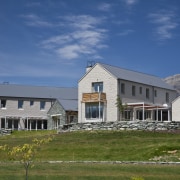 Exterior view of a home which features a cloud, cottage, elevation, estate, facade, farmhouse, home, house, landscape, mountain, property, real estate, residential area, roof, rural area, siding, sky, blue, brown