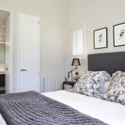 View of bedroom featuring bed with white linen, bed frame, bedroom, home, interior design, real estate, room, suite, wall, window, gray, white