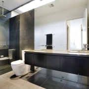 view of the ensuite bathroom which features a bathroom, countertop, floor, interior design, room, sink, white, black