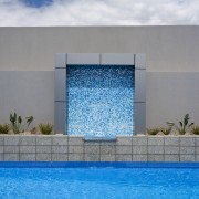 View of a paved pool area which features architecture, daytime, facade, house, property, real estate, sky, swimming pool, water, gray, teal