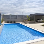 View of a paved pool area which features architecture, condominium, estate, home, house, leisure, property, real estate, swimming pool, water, white