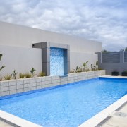 View of a paved pool area which features architecture, condominium, estate, home, house, leisure, property, real estate, sky, swimming pool, villa, water, teal, gray