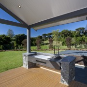 View of DRH show home outdoors kitchen which architecture, daylighting, deck, estate, floor, home, house, interior design, outdoor structure, porch, property, real estate, roof, wood, gray