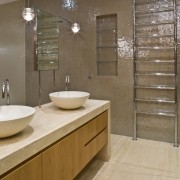 View of contemporary bathroom with mirror wall, white bathroom, cabinetry, countertop, floor, flooring, interior design, room, sink, tile, brown