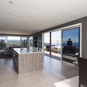 View of the kitchen area which features an apartment, estate, floor, flooring, house, interior design, penthouse apartment, property, real estate, window, gray