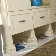 View of a bedroom which features cabinetry from chest of drawers, drawer, floor, flooring, furniture, hardwood, nightstand, product, room, table, tile, wood stain, orange, brown