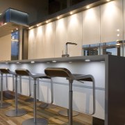 View of kitchen which features timber flooring, bar cabinetry, countertop, furniture, interior design, kitchen, product design, gray