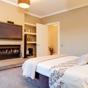 View of the bedroom which features under-floor insulation, bedroom, home, interior design, real estate, room, suite, orange, white