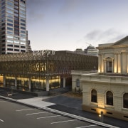 Exterior view of the Supreme Court which features architecture, building, car, city, cityscape, downtown, evening, facade, infrastructure, landmark, metropolis, metropolitan area, neighbourhood, plaza, road, sky, skyscraper, street, town square, transport, urban area, gray, brown