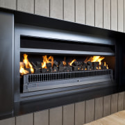 View of a living area which features a fireplace, hearth, heat, wood burning stove, black, gray