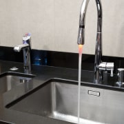 View of contemporary kitchen with dark cabinets and bathroom sink, countertop, plumbing fixture, product design, sink, tap, white, black