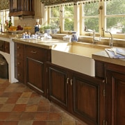 View of French-styled farmhouse kitchen which features terra cabinetry, countertop, cuisine classique, floor, flooring, furniture, hardwood, interior design, kitchen, laminate flooring, room, tile, wood, wood flooring, wood stain, brown