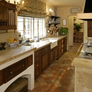 View of French-styled farmhouse kitchen which features terra cabinetry, countertop, cuisine classique, flooring, interior design, kitchen, room, brown