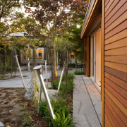 View of private courtyard which features native planting, architecture, backyard, cottage, courtyard, home, house, leaf, outdoor structure, plant, porch, real estate, residential area, siding, tree, walkway, yard, brown