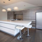 View of a kitchen which features white CeasarStone architecture, cabinetry, countertop, floor, flooring, hardwood, interior design, kitchen, laminate flooring, real estate, room, wall, window, wood, wood flooring, gray