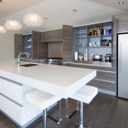 View of a kitchen which features white CeasarStone ceiling, countertop, floor, furniture, interior design, kitchen, room, table, gray