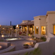 Exterior view of this home featuring unique landscape estate, evening, hacienda, home, hotel, landscape lighting, lighting, property, real estate, resort, sky, villa, blue