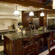 View of a traditional-styled kitchen which features dark-stained countertop, interior design, kitchen, room, red, brown, orange