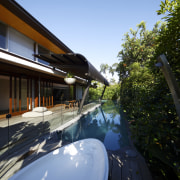 Exterior view of this contemporary home by Arkhefield architecture, automotive exterior, house, plant, real estate, reflection, residential area, roof, sky, tree, water, black, teal