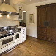 View of a traditional-styled kitchen which features stainless cabinetry, countertop, cuisine classique, floor, flooring, hardwood, home appliance, interior design, kitchen, laminate flooring, real estate, room, tile, wood, wood flooring, brown, orange