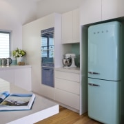 View of kitchen with light toned cabinetry, wooden cabinetry, floor, home appliance, interior design, kitchen, major appliance, refrigerator, room, gray