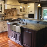 View of kitchen which features sink and arched cabinetry, countertop, cuisine classique, floor, flooring, hardwood, interior design, kitchen, room, wood flooring, black