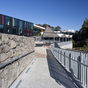 Exterior view of a concrete pathway at Albany architecture, building, facade, house, real estate, sky, structure, tree, walkway, wall, gray
