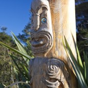 Close-up view of the garden's Maori sculpture - artifact, carving, grass, outdoor structure, sculpture, tiki, totem, totem pole, tree