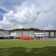 Exterior view from the fields - Exterior view architecture, campus, cloud, corporate headquarters, facade, grass, house, real estate, sky, sport venue, stadium, structure, gray