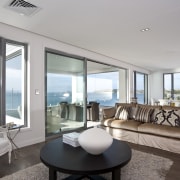 View of lounge featuring sofas, oak floors, rug, apartment, condominium, home, house, interior design, living room, penthouse apartment, property, real estate, window, gray