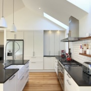 View of renovated kitchen which features timber floors, cabinetry, ceiling, countertop, cuisine classique, daylighting, floor, hardwood, interior design, kitchen, room, wood flooring, gray