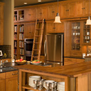 View of a Northwestern-styled kitchen with extensive wood cabinetry, countertop, cuisine classique, furniture, hardwood, interior design, kitchen, room, under cabinet lighting, wood, wood stain, brown