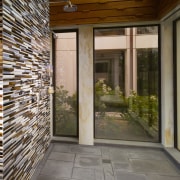 View of contemporary interior with distinctive tile wall architecture, brick, courtyard, door, estate, facade, home, house, interior design, lobby, patio, porch, property, real estate, siding, wall, window, gray, brown