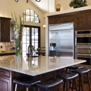View of a Tuscan-styled kitchen which features dark-stained cabinetry, countertop, cuisine classique, interior design, kitchen, real estate, red