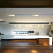 View of kitchen area featuring hardwood flooring, island architecture, ceiling, daylighting, floor, flooring, hardwood, house, interior design, lighting, loft, room, wood, brown, gray